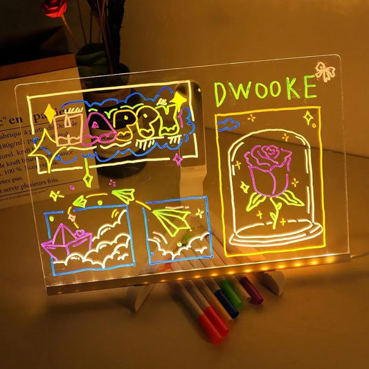 Transparent board with colorful drawings and text, illuminated by LED lights, on a wooden surface.